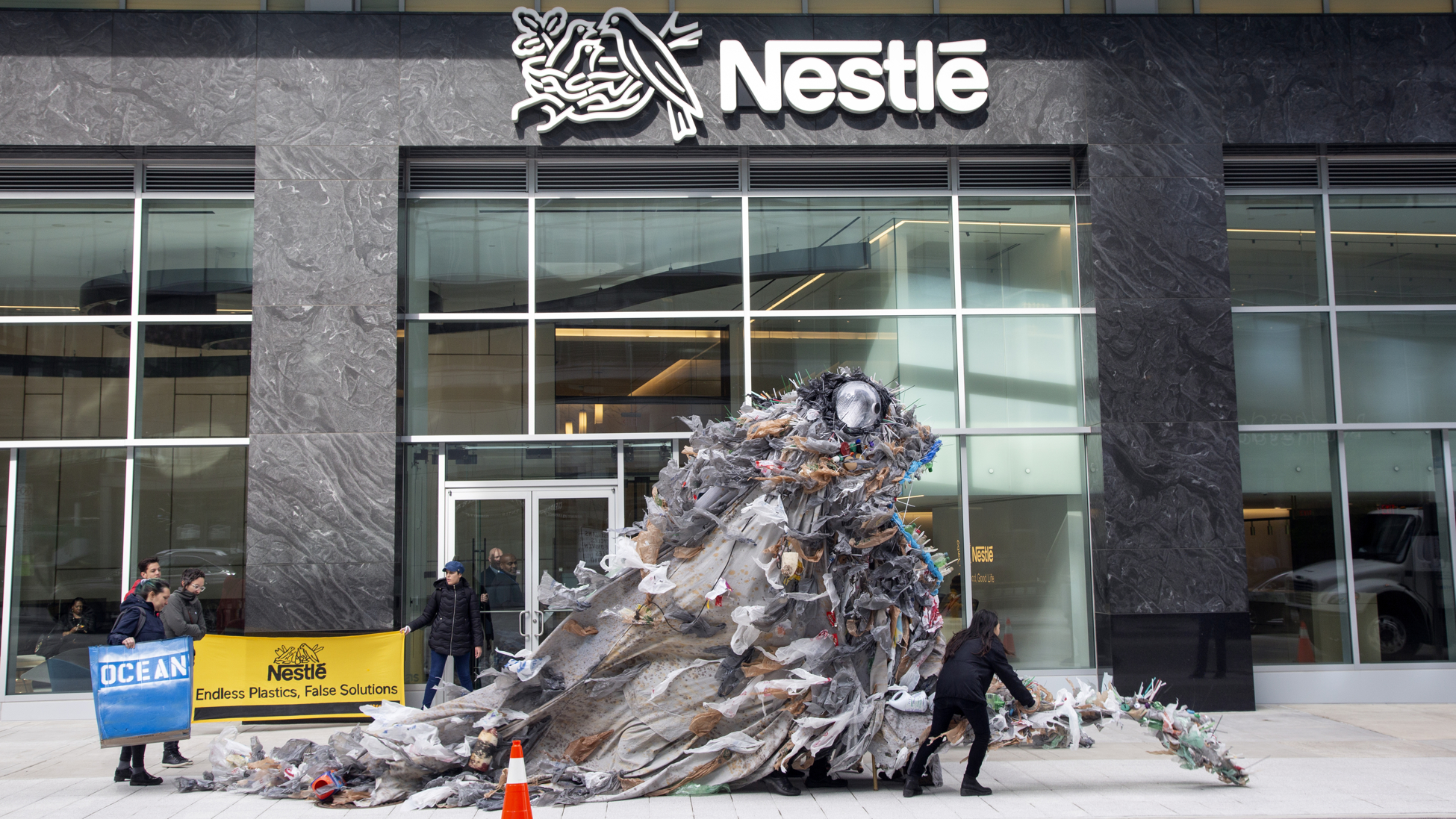Activists deliver giant trash monsters to Nestlé headquarters to protest plastic pollution